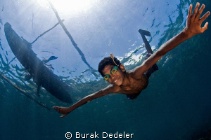 A young boy free diving from his dug out canoe with home ... by Burak Dedeler 